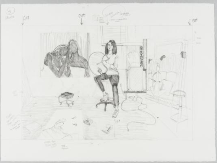 A black and white pencil drawing shows an artist sitting in her studio.