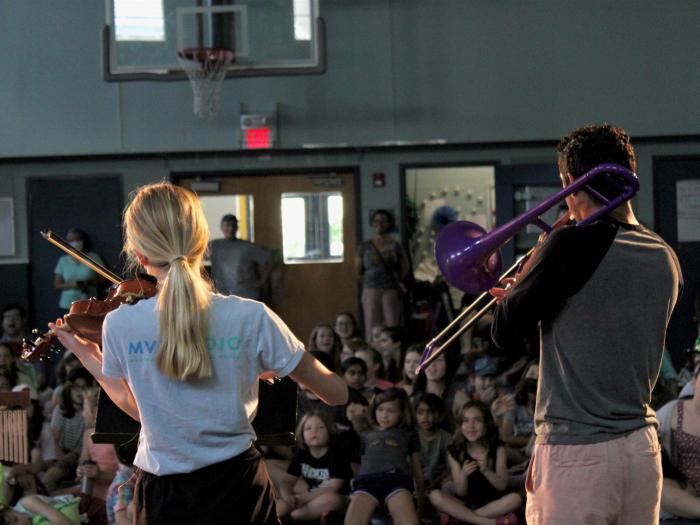 Photo of two Fayerweather students playing musical instruments at a school concert.