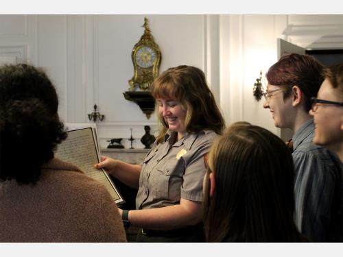 National Park Ranger talking with four visitors inside a historic house.